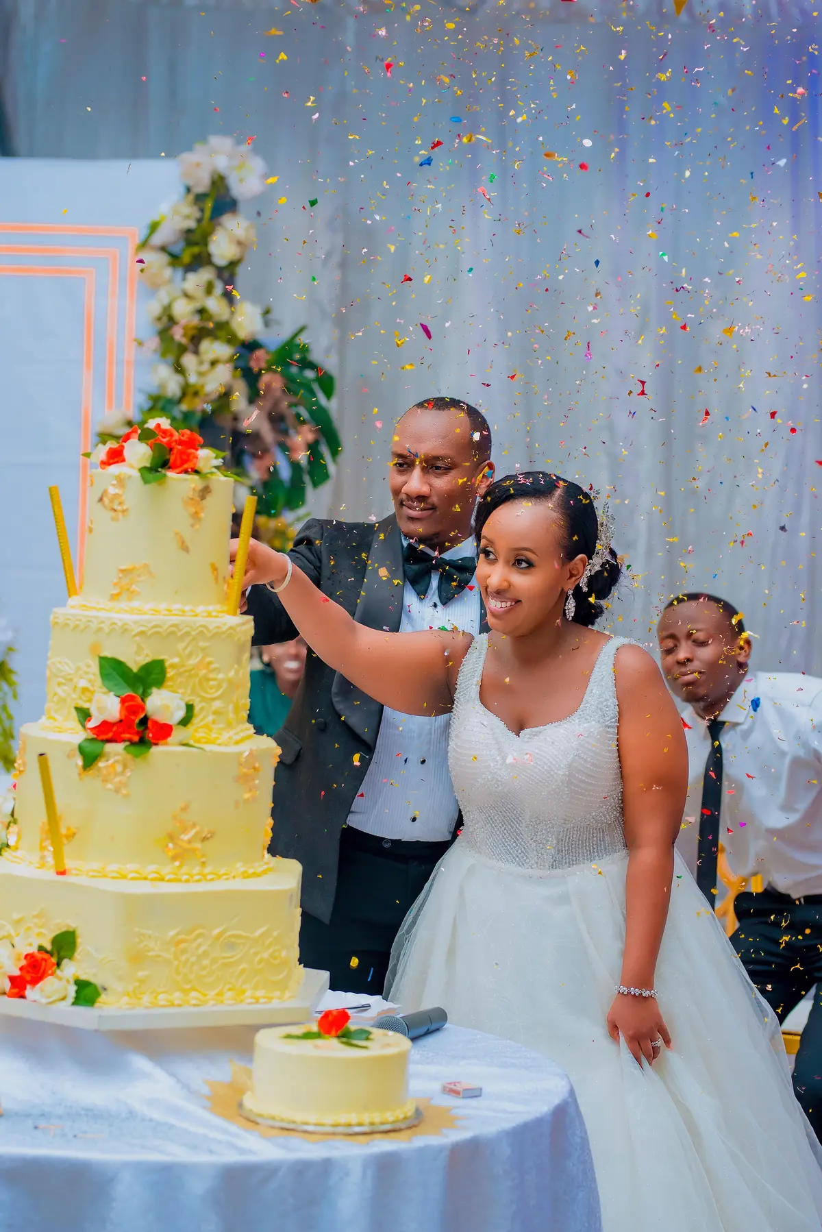 Couple cutting wedding cake with confetti - wedding videography photography Kigali